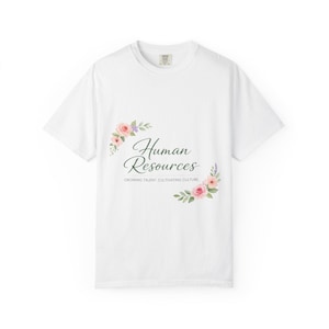 May include: White t-shirt with the words "Human Resources" in a script font, accompanied by floral accents in pink, purple, and green. The text "Growing Talent, Cultivating Culture" is below the main text.