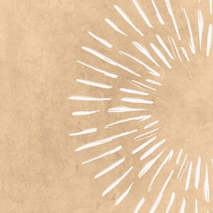 May include: Abstract art print featuring a sunburst design. The artwork showcases a radial pattern of white brushstrokes against a textured, tan background. The design evokes a sense of energy and movement, suitable for modern decor.