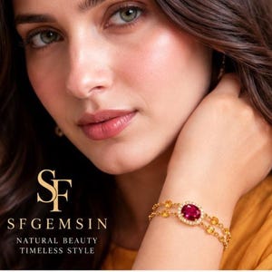 Peut inclure: Un bracelet en chaîne dorée avec une pierre rouge centrale de taille ovale entourée d'un halo de petites pierres blanches, agrémenté de pierres jaunes plus petites sur la double chaîne. Le texte SF GEMSIN NATURAL BEAUTY TIMELESS STYLE est visible.