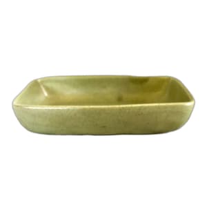 Pode incluir: Um prato retangular de cerâmica com um esmalte verde claro salpicado. O prato apresenta cantos arredondados, lados ligeiramente inclinados e um acabamento suave e uniforme em toda a sua superfície, apresentando um design de recipiente aberto.