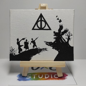 Peut inclure: Petite peinture sur toile carrée, présentée sur un chevalet en bois. L'œuvre présente une scène en silhouette noire avec des personnages, un symbole et un arbre sur fond blanc. Il s'agit d'une œuvre de fan art.