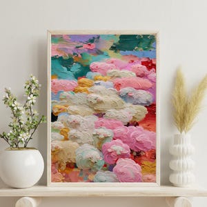 Può includere: Stampa artistica astratta in una cornice di legno chiaro. L'opera presenta un paesaggio strutturato e colorato con pennellate rosa, gialle, turchesi e bianche. Il dipinto è esposto su una mensola bianca con vasi decorativi.