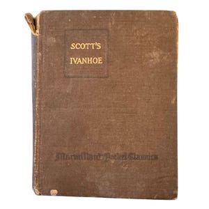 May include: A vintage, brown hardcover book titled "Scott's Ivanhoe." The book's cover features gold lettering and a rectangular design. The bottom of the book reads "Macmillan's Pocket Classics."