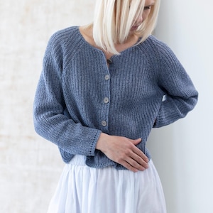Woman wearing blue knit cardigan, soft relaxed silhouette