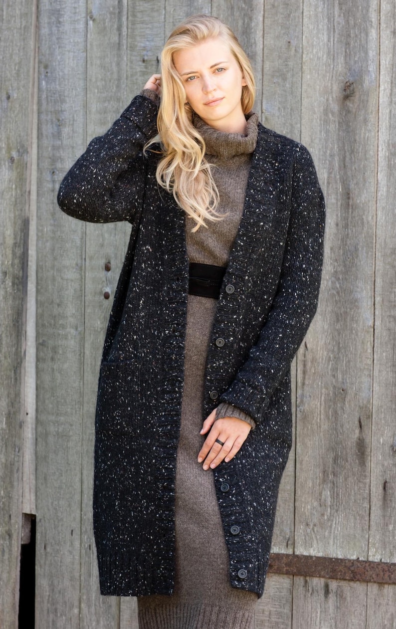 Woman wearing long Irish Donegal wool cardigan outdoors in autumn setting, black