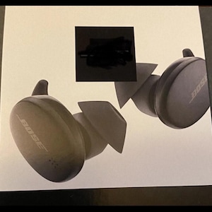 May include: Dark gray wireless earbuds with the brand name "BOSE" printed on the side. The earbuds are displayed on a white background, with a black square covering part of the image.