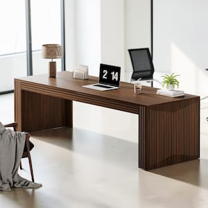 May include: A dark brown wooden desk with a laptop displaying "2 14" on the screen. A desk lamp, a small plant, and a glass are on the desk. The desk has a rectangular shape with vertical lines on the sides.