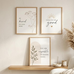 Może przedstawiać: Trzy oprawione wydruki artystyczne z inspirującymi cytatami i ilustracjami botanicznymi. Pierwszy wydruk głosi "Be kind to your mind", drugi "Focus on the good", a trzeci "You are capable of amazing things".