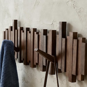 Puede incluir: Un letrero de madera rústica con el texto "Welcome to our home" en letras blancas. El letrero presenta un acabado envejecido y un diseño sencillo y acogedor, ideal para un porche o entrada.