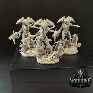 Pode incluir: Três figuras cinzentas em miniatura de criaturas alienígenas com características de insetos, posando sobre uma base de entulho. Cada figura tem uma crista de cabeça distinta e braços armados. O logotipo Voidhive Forge é visível no canto inferior direito.