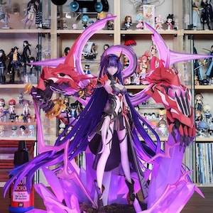 May include: A detailed anime-style figurine of a female character with long purple hair and a black and white outfit. The figure is posed on a purple crystal base, with red and purple accents. The background features a collection of other figurines.