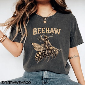 Puede incluir: Juego de tres tazas de cerámica con acabado mate moteado. Las tazas son de color crema, gris claro y gris oscuro. Cada taza tiene un diseño simple y moderno y un asa redondeada.