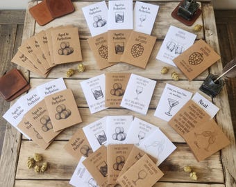 May include: A collection of rectangular greeting cards featuring various illustrations of barrels, glasses, and hops. The cards include text such as Aged to Perfection, Happy Birthday, and I'm Not Saying You're Old, printed in black ink on white and brown paper.