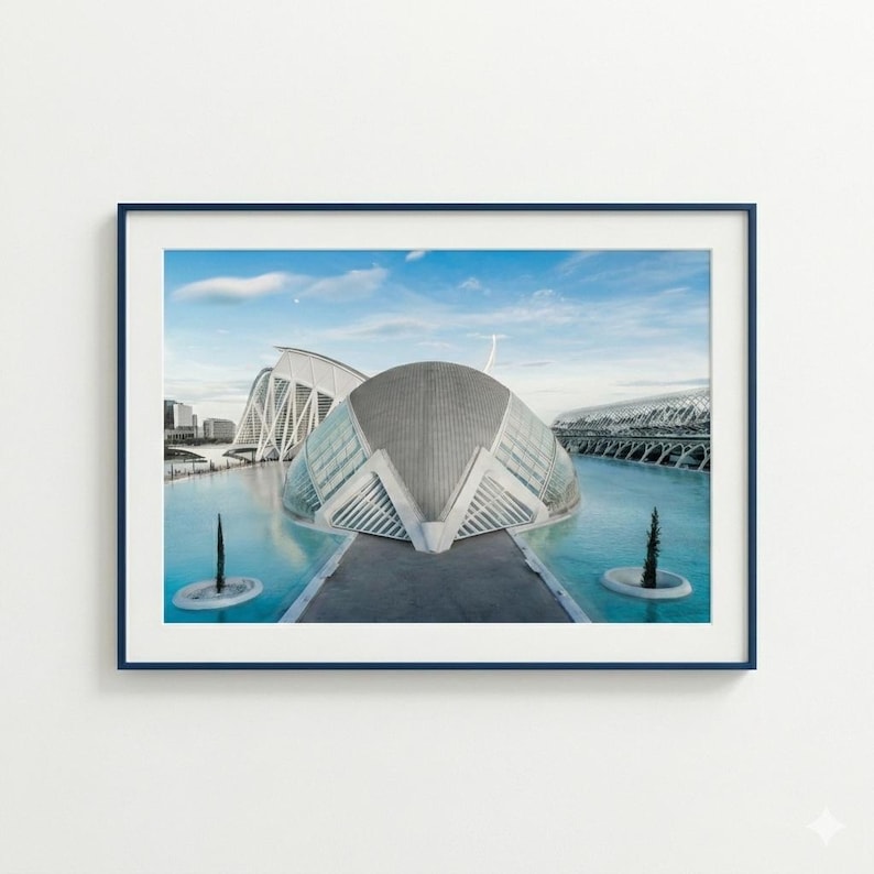 May include: A framed print featuring a modern architectural complex with a distinctive, curved design. The buildings are set against a backdrop of a bright blue sky and water, creating a serene and contemporary aesthetic.