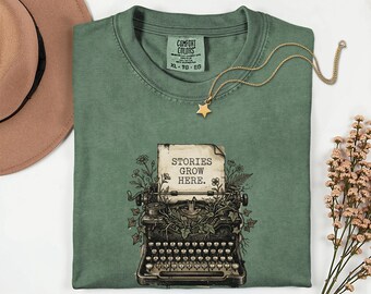 Maglietta Stories Grow Here Comfort Colors® 1717 / Maglietta floreale per macchina da scrivere / Regalo per scrittore e autore / Maglietta per poeta Dark Academia / Maglietta per insegnante di inglese