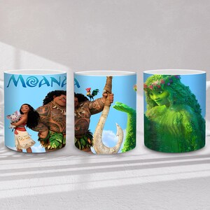 May include: Three white ceramic mugs featuring characters from the animated film "Moana." The mugs display images of Moana, Maui, and Te Fiti against a blue sky background. The word "MOANA" is printed in blue on one of the mugs.