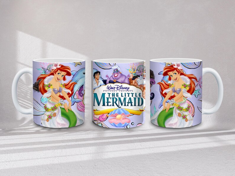 May include: White ceramic mug featuring Ariel from Disney's The Little Mermaid. The mug has a wraparound design with Ariel, a dolphin, and the movie's logo. The background is a light purple with stars and other sea creatures.
