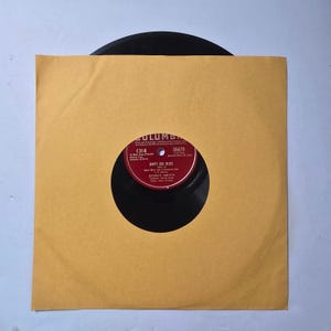 May include: A vintage vinyl record in a yellow paper sleeve. The record label is red and white with the text "EMPTY BED BLUES" and "BESSIE SMITH". The record is a 78 RPM, a classic jazz record.