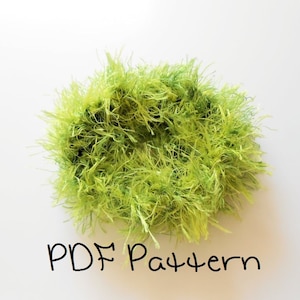 May include: A green fluffy yarn wreath with the text "PDF Pattern" written below it.