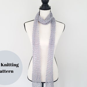 May include: A gray knitted scarf draped on a white mannequin. The scarf is made with a delicate stitch pattern. The text "PDF Knitting Pattern" is visible in the lower left corner of the image.
