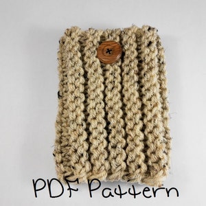 May include: A hand-knitted beige and brown rectangular item with a wooden button closure. The item is made of thick yarn and has a textured appearance. The words "PDF Pattern" are written in black script at the bottom.