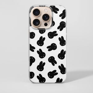 Puede incluir: Funda transparente para tel&eacute;fono con fondo blanco y un patr&oacute;n repetido de caras de conejos negros. La funda tiene un recorte para la c&aacute;mara y est&aacute; dise&ntilde;ada para un tel&eacute;fono inteligente.