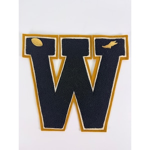May include: A large letter W patch featuring dark navy blue chenille fabric with a thick mustard yellow border and a white inner trim. The left top section displays a small gold football icon, while the right top section features a gold wing icon.