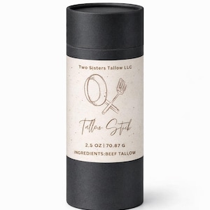 Op de afbeelding: Een zwarte cilindrische container met een label met de tekst "Two Sisters Tallow LLC" en "Tallow Stick". Het label bevat ook een tekening van een spatel en een lepel, en de tekst "2.5 OZ | 70.87 g INGREDIENTS: BEEF TALLOW."