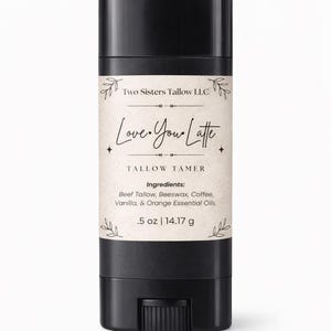 Könnte beinhalten: Ein schwarzer, zylindrischer Tallow Tamer-Stick mit einem Etikett mit der Aufschrift "Love You Latte". Das Etikett listet die Zutaten auf: Rindertalg, Bienenwachs, Kaffee, Vanille und ätherische Öle aus Orangen. Es ist 14,17 g.