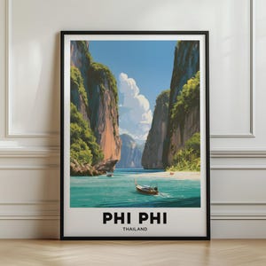 May include: A framed travel poster featuring a vibrant illustration of Phi Phi, Thailand. The artwork depicts towering limestone cliffs, lush green vegetation, turquoise water, and a traditional long-tail boat. The text reads PHI PHI THAILAND.