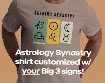 May include: A tan t-shirt with the text "SEEKING SYNASTRY" above three colored rectangles with astrological symbols. Below, the shirt reads "Astrology Synastry shirt customized w/ your Big 3 signs!"
