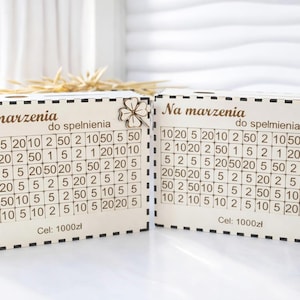 May include: A white ceramic mug with a black handle and the text "But First, Coffee" in a black, handwritten-style font. The mug is on a white surface.
