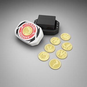 May include: A white and black morpher device with a central gold dinosaur emblem and the text POWER RANGERS in red, accompanied by a black base and seven circular gold coins featuring various embossed animal and lightning bolt designs.