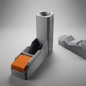 May include: A grey 3D-printed dice tower with a vertical cylindrical opening and a rectangular tray containing a stack of orange square tiles. A separate grey geometric piece with angled ridges sits to the right of the main tower structure.