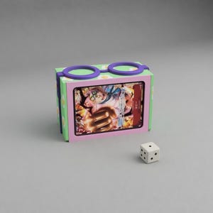 May include: A colorful card box with a card inside, a white die with black dots, and a pair of purple and green glasses on top. The box is decorated with daisies and has a pink frame around the card.