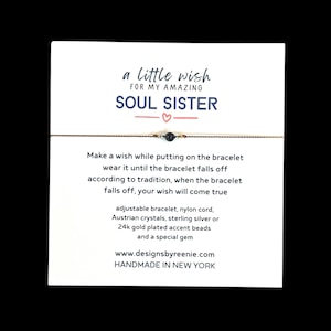May include: A delicate bracelet on a white card with the text "a little wish for my amazing soul sister." The bracelet is made of nylon cord, Austrian crystals, and 24k gold plated accent beads. The card also includes instructions and website information.