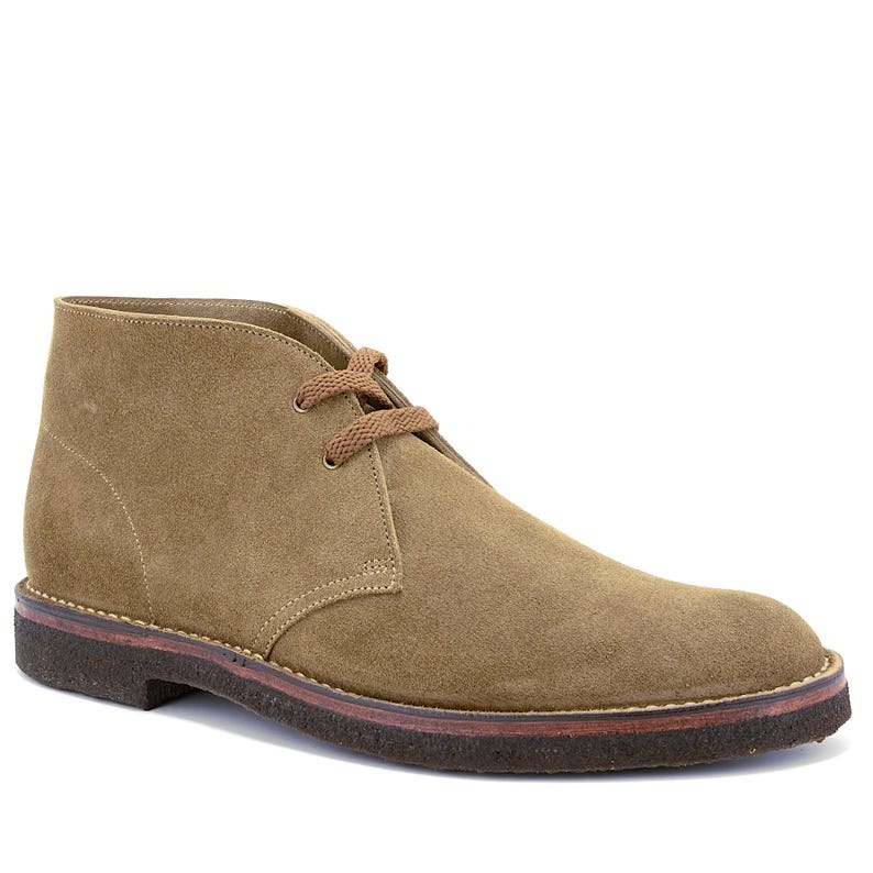 May include: A tan suede chukka boot with brown laces and a dark brown sole. The boot has a classic design with a rounded toe and a mid-height ankle. The sole is made of a durable material.