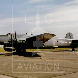 May include: A grey Royal Air Force bomber aircraft on a runway. The aircraft has two engines, a high wing, and a tail with the number 90 and a British flag. The number 8 is visible on the side of the plane.