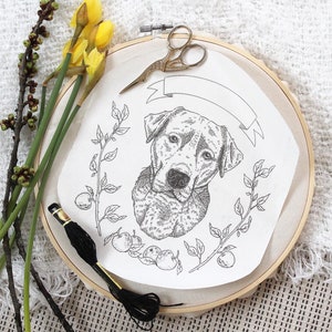 Puede incluir: Un aro de bordado en blanco y negro con un dibujo de la cabeza de un perro y una pancarta con el texto "Mi mejor amigo". El aro está rodeado de un diseño floral.