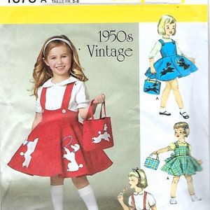 May include: Simplicity sewing pattern for a vintage 1950s girl's dress. The pattern features a red dress with white poodle designs, a matching tote bag, and a white blouse. The pattern size is U.S. 3-8.