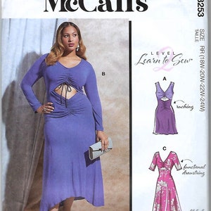 May include: A McCall's M8253 sewing pattern envelope featuring a long-sleeved, periwinkle blue midi dress with a front cutout, drawstring ruching, and a V-neckline. The package displays illustrations of variations A and C, including floral prints.