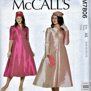 May include: McCALL'S M7806 sewing pattern envelope featuring two variations of a mid-length dress with a collar, buttoned waist detail, and flared skirt. View A is magenta with a pillbox hat, and View B is champagne with a matching hat and clutch.