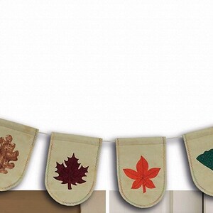 May include: A decorative bunting banner featuring ten beige fabric pennants suspended on a white string. Each pennant displays a unique, colorful leaf print in shades of red, orange, dark green, and brown, representing various tree species.