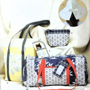 May include: A collection of fabric accessories including a yellow and white floral tote bag with gray straps, a blue and white patterned duffel bag with orange straps and a luggage tag, a small zippered pouch, a glasses case, and a white sun hat.