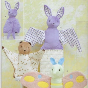 May include: A collection of plush toys, including a purple bat with patterned wings, a brown bear with cream-colored wings, and a green and pink butterfly. The toys are made of soft fabric and are designed for children.