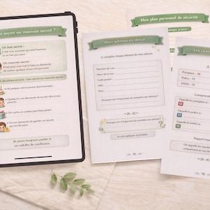 Może przedstawiać: Otwarty tablet wyświetla stronę zatytułowaną "Bon secret ou mauvais secret?" z ilustracjami i tekstem. Obok znajdują się wydrukowane strony z tytułami takimi jak "Mon adresse en detail" i "Les numeros d'urgence". Widoczny jest również ołówek i gałązka.