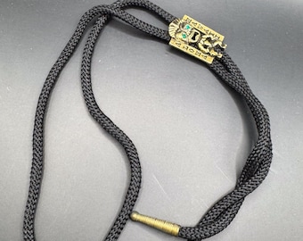 Vintage Hawaiian Tiki Bolo Tie: Gold Tone Aloha Hawaii, Black Cord, Green Rhinestone Eyes