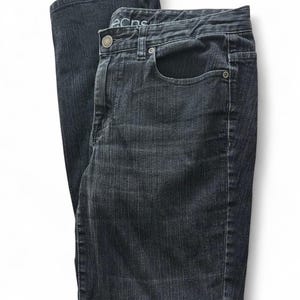 May include: Dark wash denim jeans with a classic five-pocket design. The jeans have a button and zipper closure, belt loops, and a subtle faded effect. The fabric appears to be a medium-weight denim.
