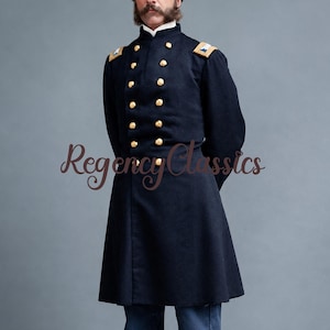 May include: A navy blue military-style coat with gold buttons and shoulder epaulets. The coat has a high collar and a long, tailored fit. The text "Regency Classics" is visible in the image. The coat appears to be made of a heavy fabric.