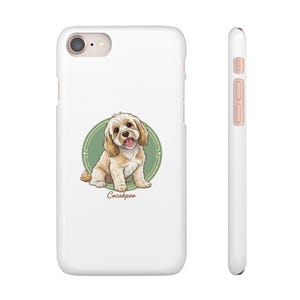 May include: White phone case featuring a cartoon illustration of a Cockapoo dog within a green oval frame. The dog is light brown with a pink tongue. The word "Cockapoo" is written in a cursive font below the dog.